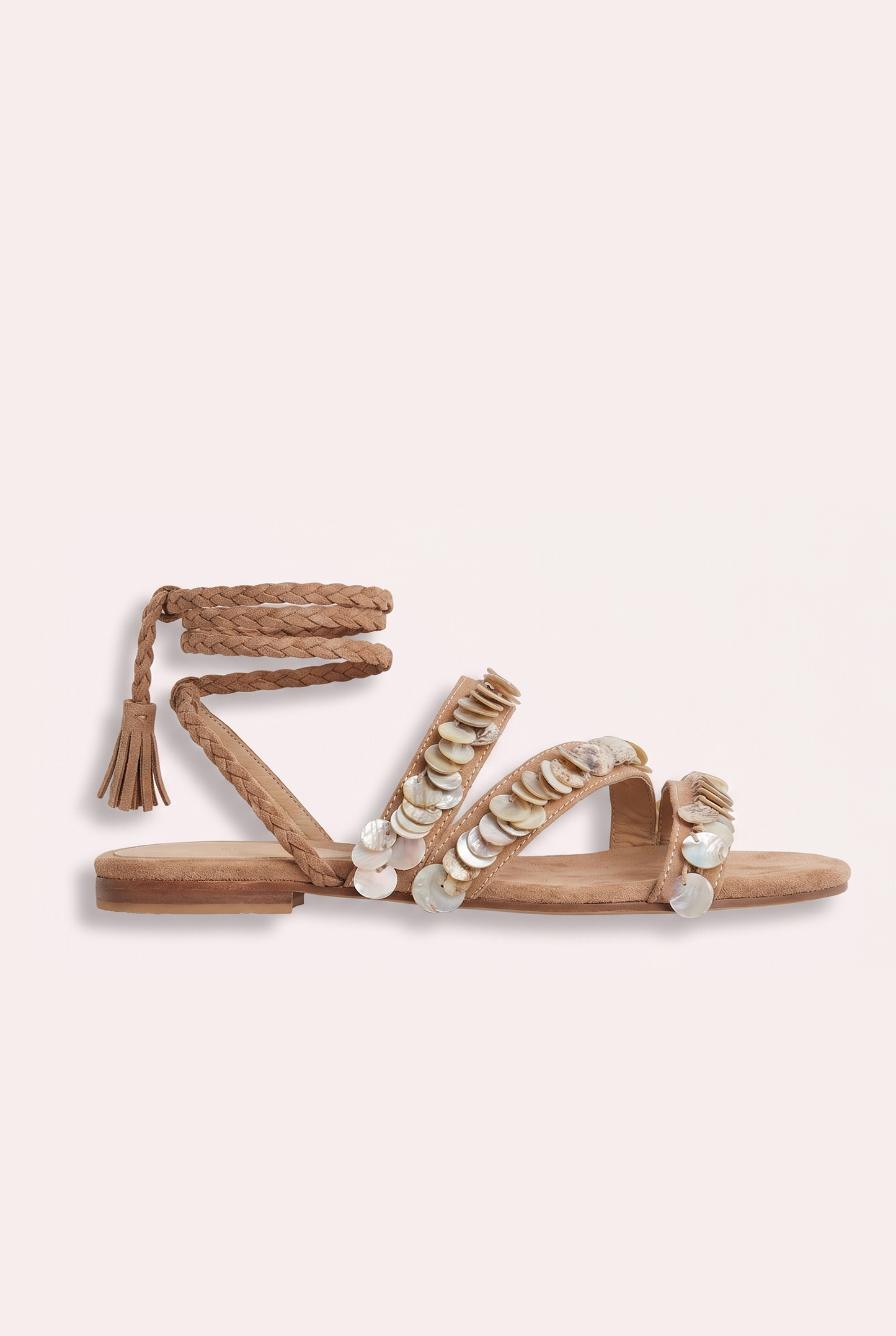 Handcrafted tan suede flat sandals with mother of pearl beads and braided wrap-around ankle ties.