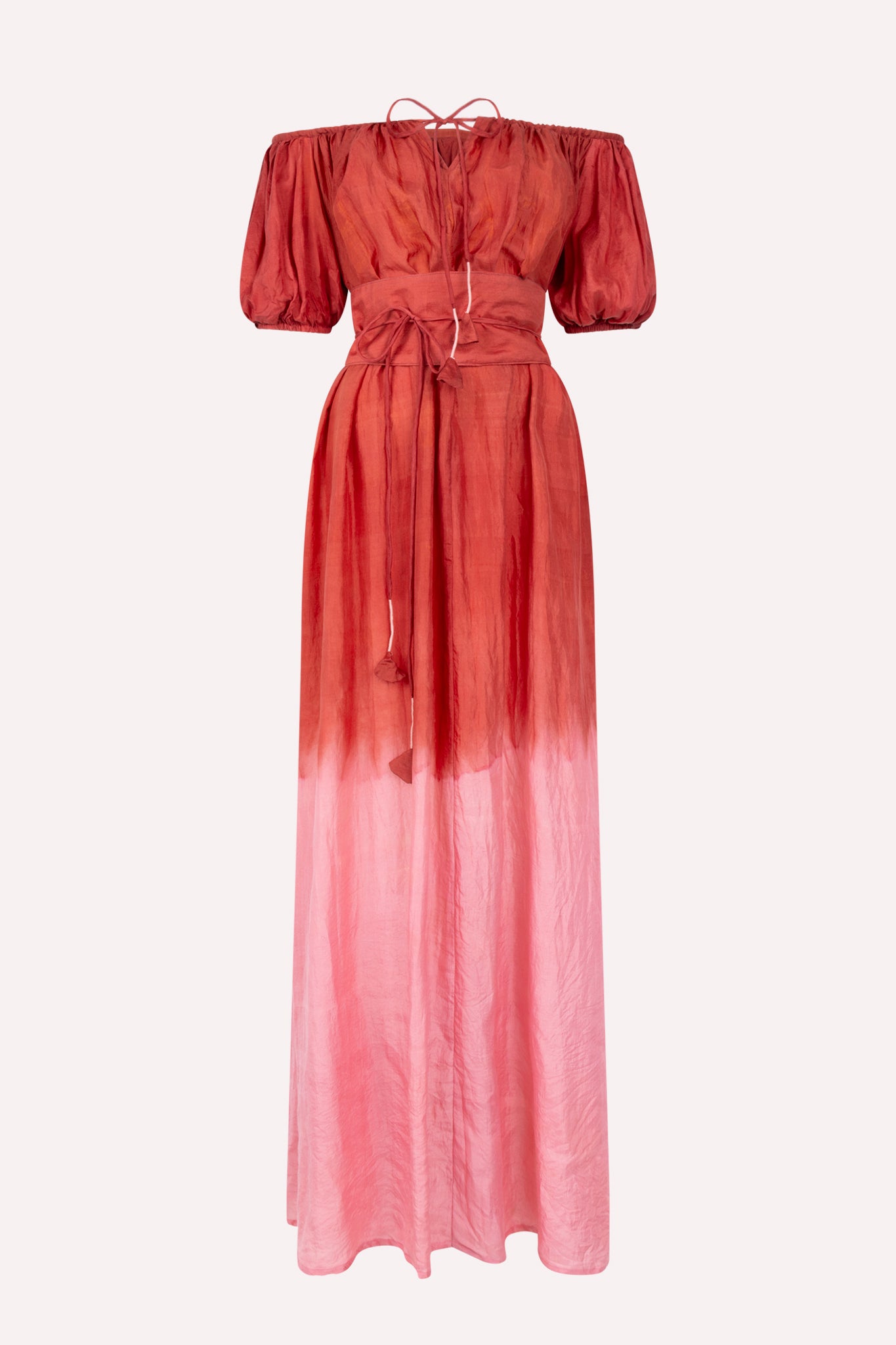 An off-shoulder, maxi dress with a gradient of red to pink color, featuring a waist accentuating belt.