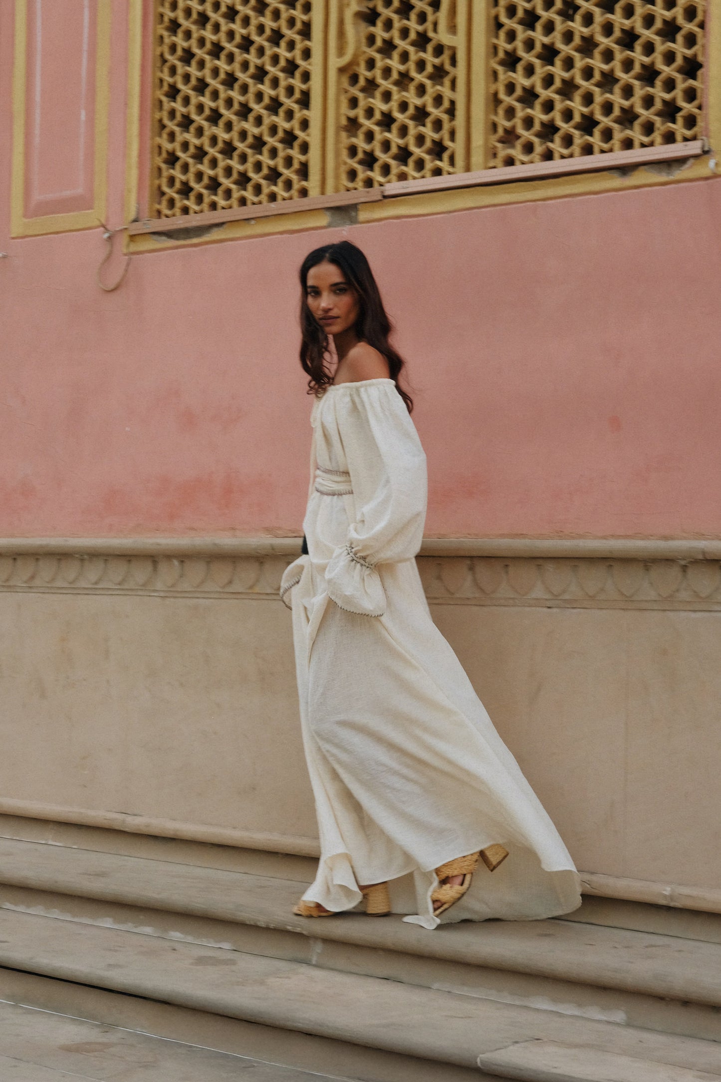
                  
                    ZAZI Vayana Dress in handwoven Khadi cotton featuring a bohemian maxi silhouette, hand-embroidered details, versatile off-shoulder neckline, long sleeves, and matching belt.
                  
                