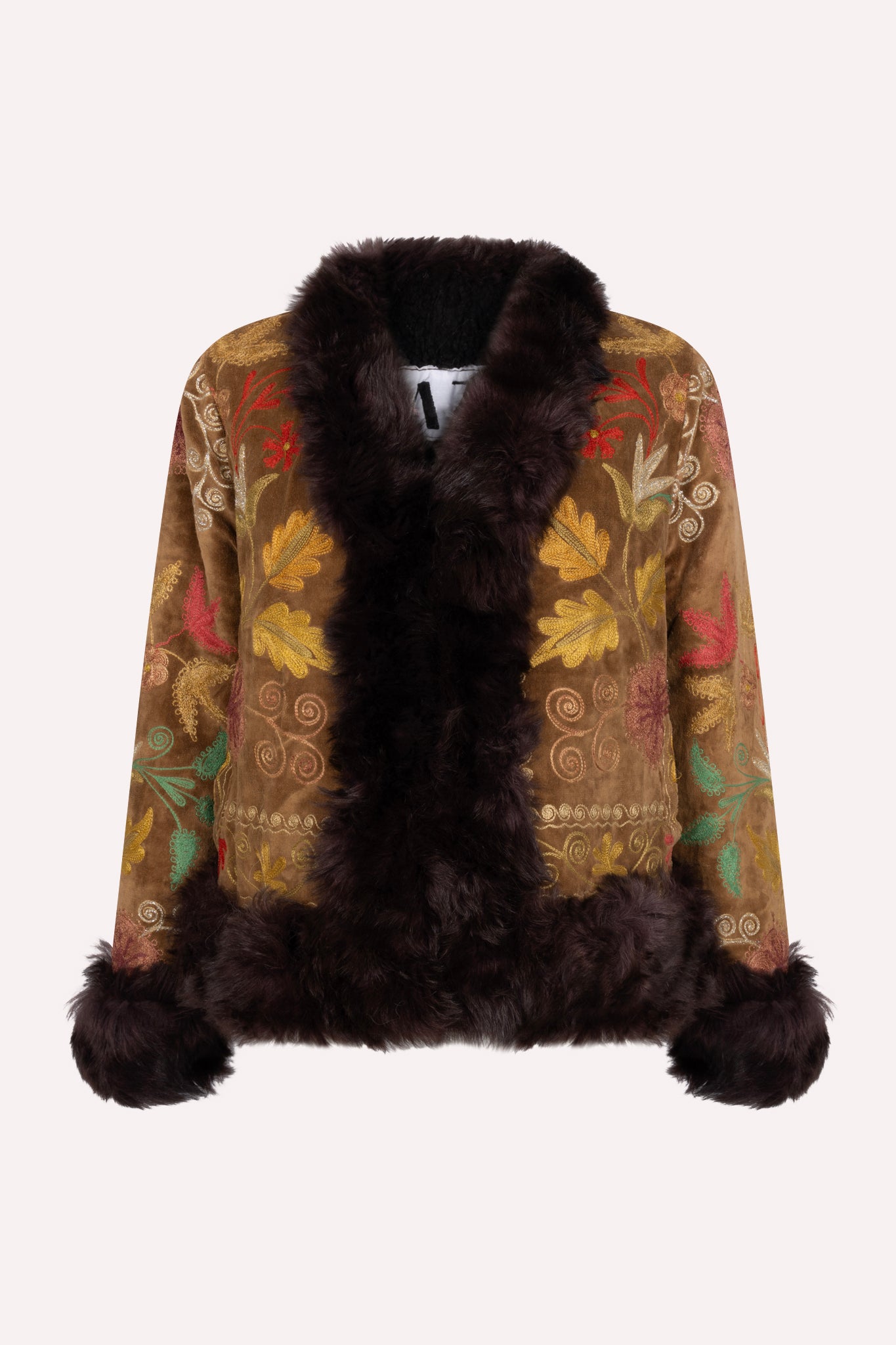 One-of-a-kind ZAZI Afghan coat crafted from vintage velours cotton suzani embroidery with an up-cycled sheepskin lining, featuring a belted 1970s Penny Lane silhouette and handcrafted by women artisans in Afghanistan.