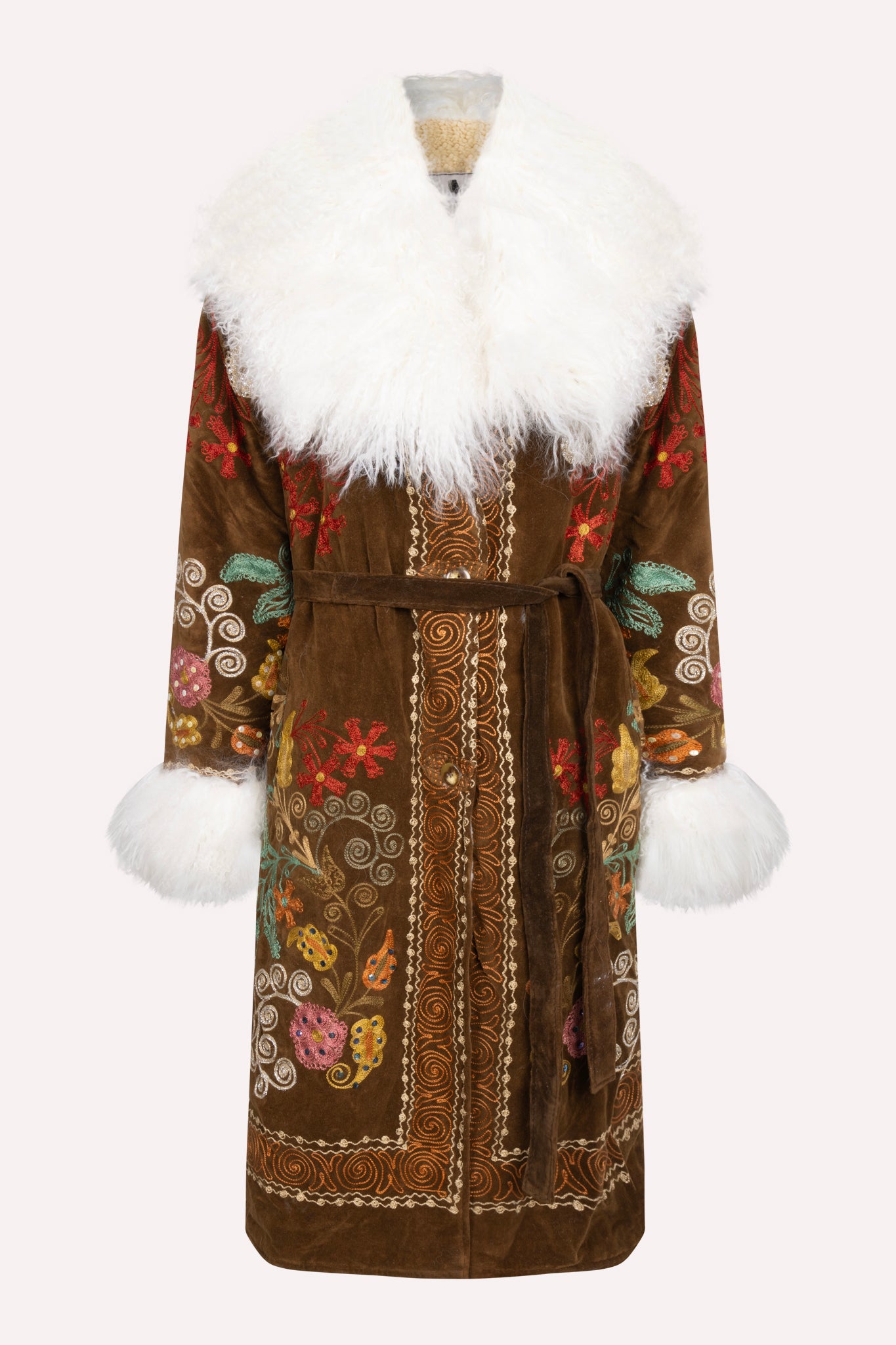 One-of-a-kind ZAZI Afghan coat crafted from vintage velours cotton suzani embroidery with an up-cycled sheepskin lining, featuring a belted 1970s Penny Lane silhouette and handcrafted by women artisans in Afghanistan.