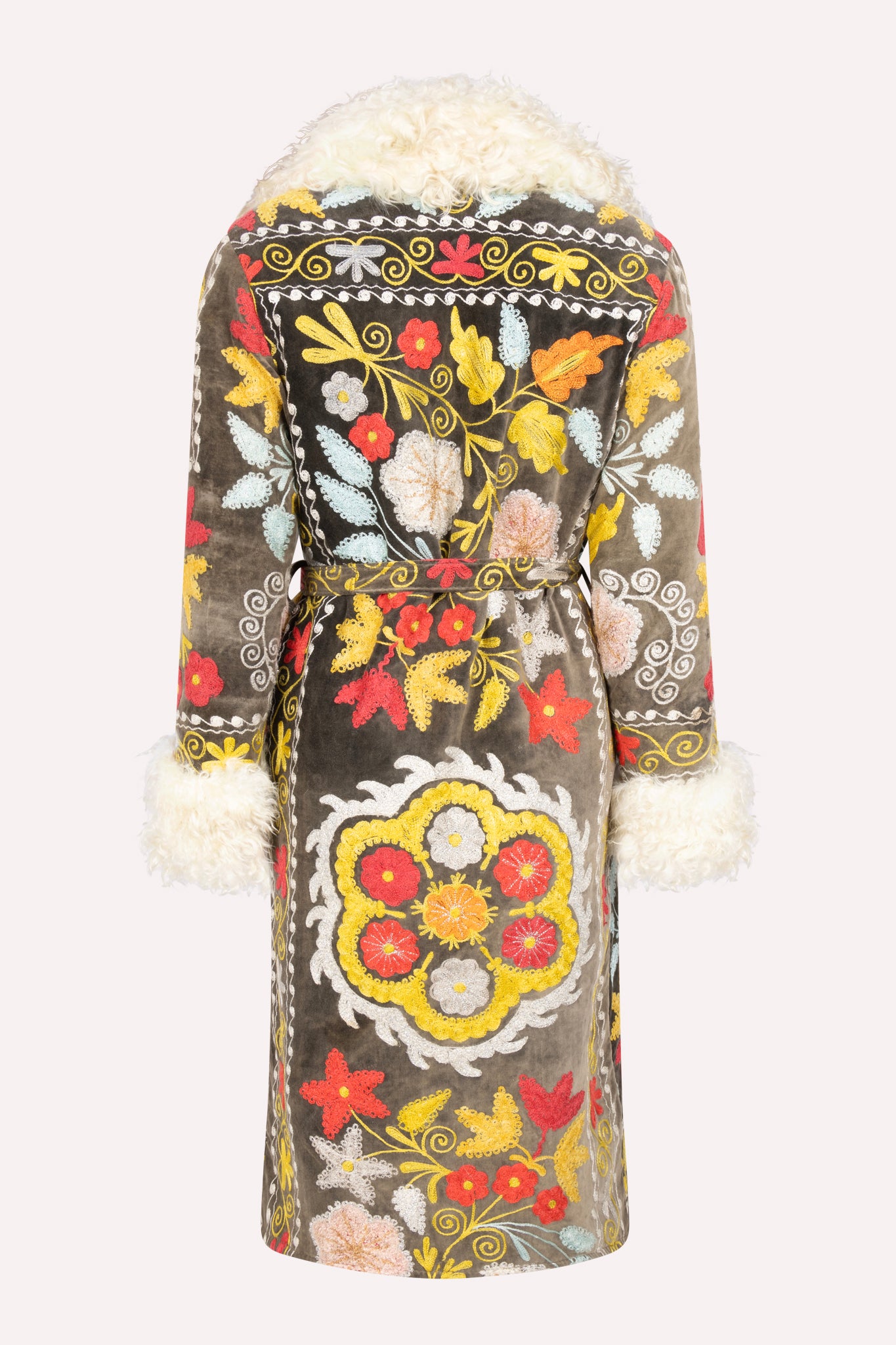 Handcrafted ZAZI Afghan coat made from vintage cotton suzani embroidery, featuring a 70s Penny Lane silhouette, belted waist, colorful floral patterns, and up-cycled sheepskin lining.
