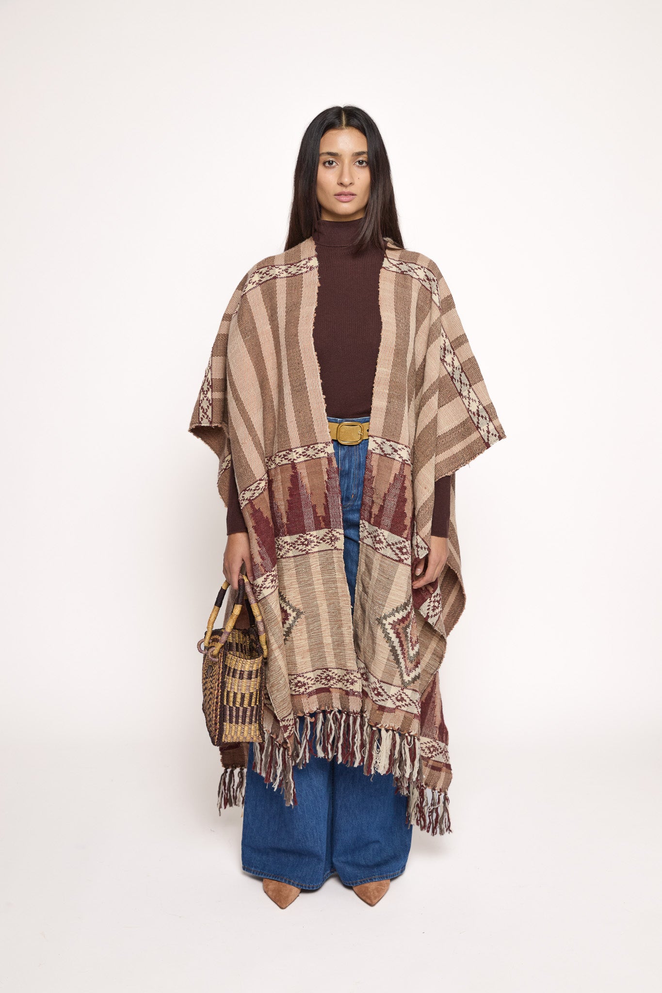 Handmade ZAZI wool cape inspired by Himalayan artisans, featuring intricate weaving, natural dyes, and tassels, modeled by a 174 cm tall woman.