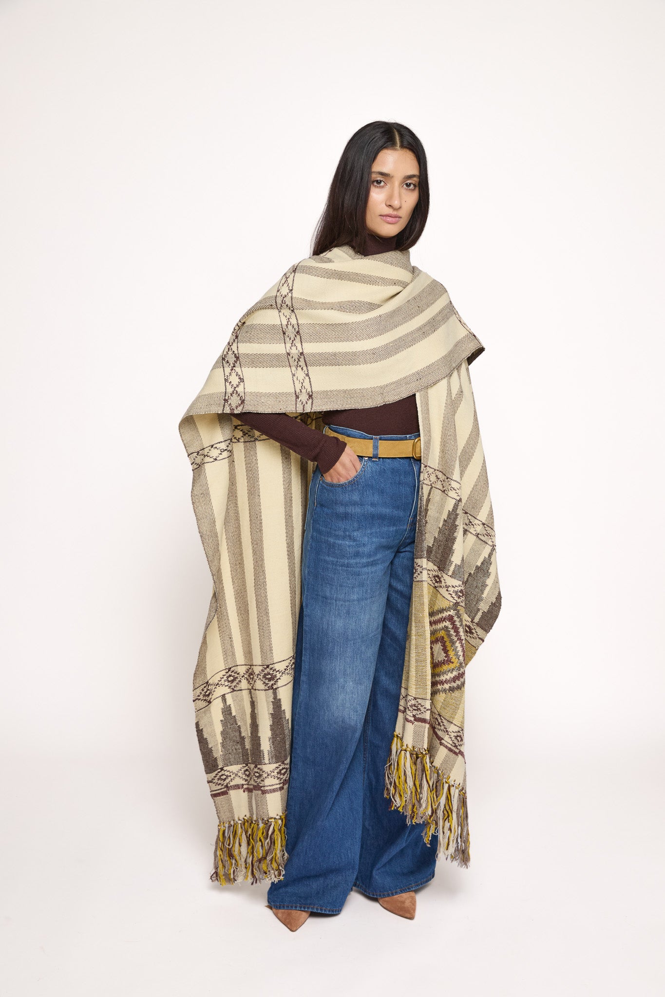Handmade ZAZI wool cape inspired by Himalayan artisans, featuring intricate weaving, natural dyes, and tassels, modeled by a 174 cm tall woman.