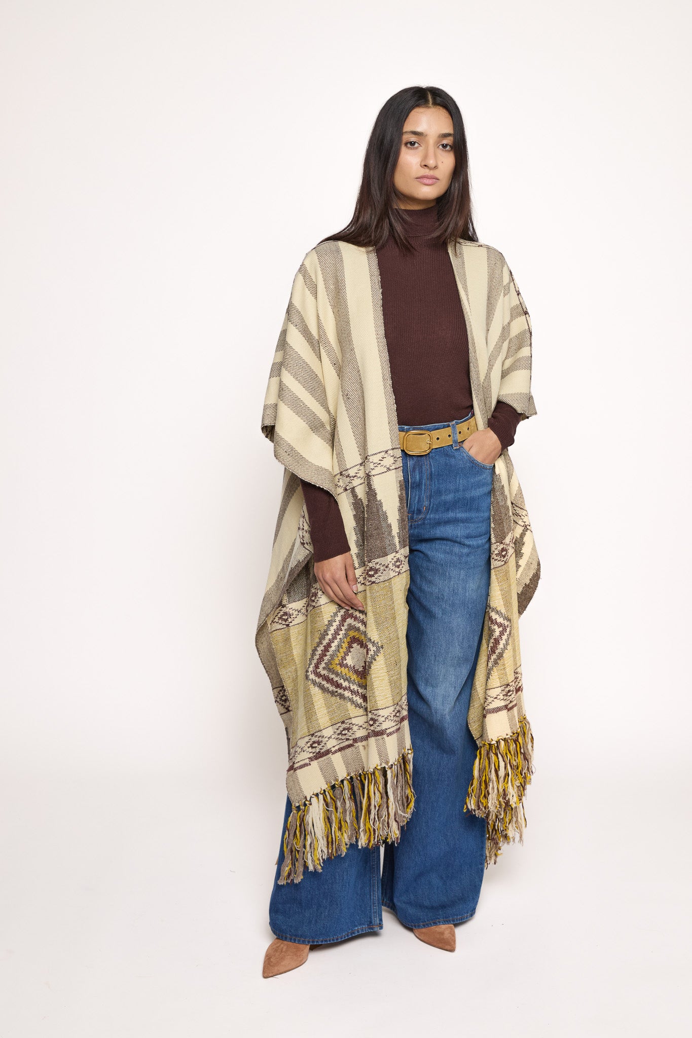 Handmade ZAZI wool cape inspired by Himalayan artisans, featuring intricate weaving, natural dyes, and tassels, modeled by a 174 cm tall woman.