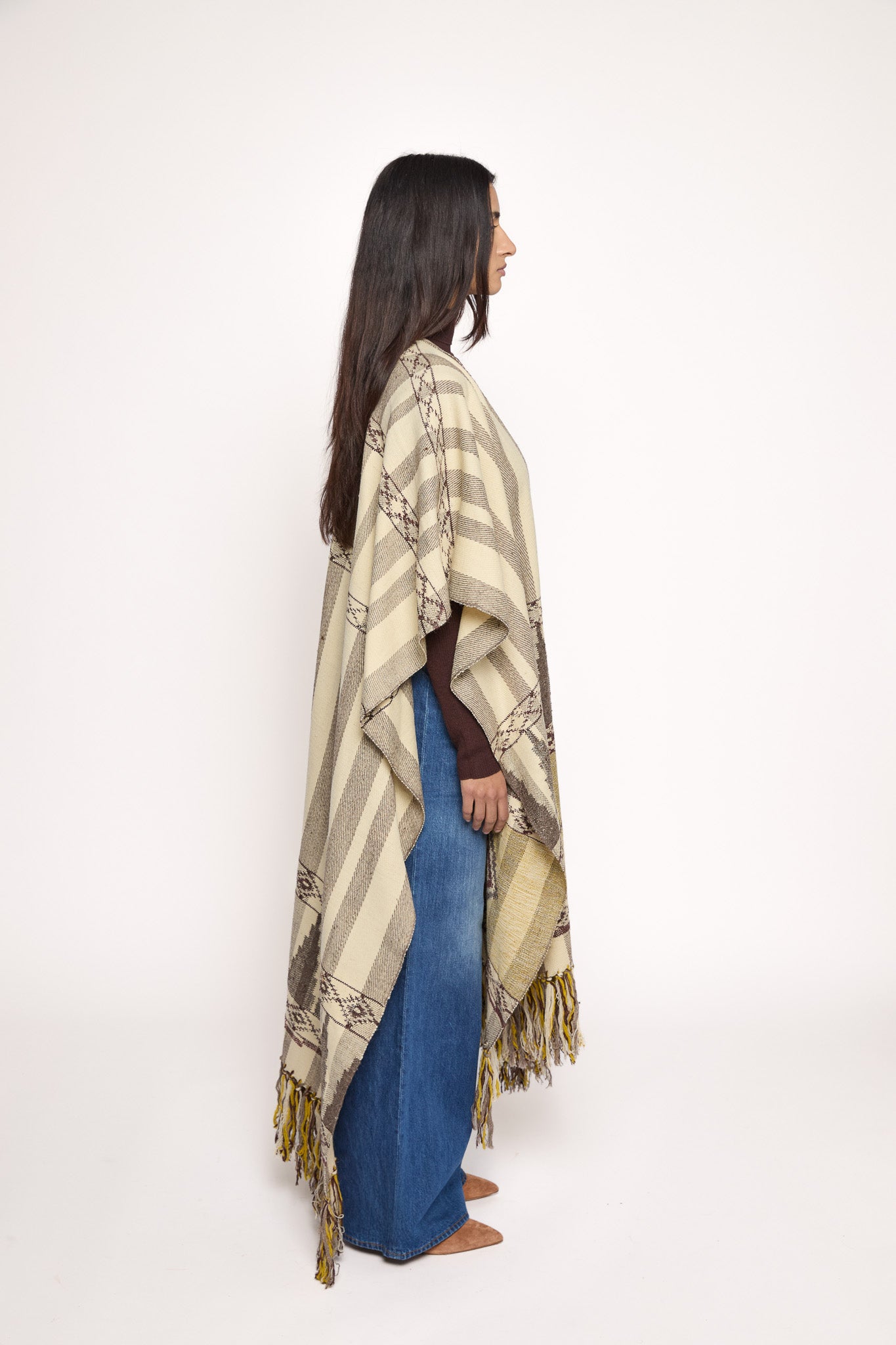 
                  
                    Handmade ZAZI wool cape inspired by Himalayan artisans, featuring intricate weaving, natural dyes, and tassels, modeled by a 174 cm tall woman.
                  
                