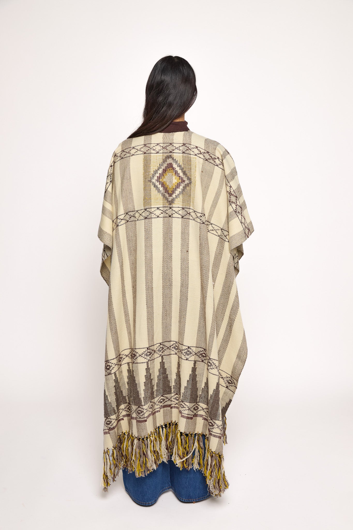 
                  
                    Handmade ZAZI wool cape inspired by Himalayan artisans, featuring intricate weaving, natural dyes, and tassels, modeled by a 174 cm tall woman.
                  
                