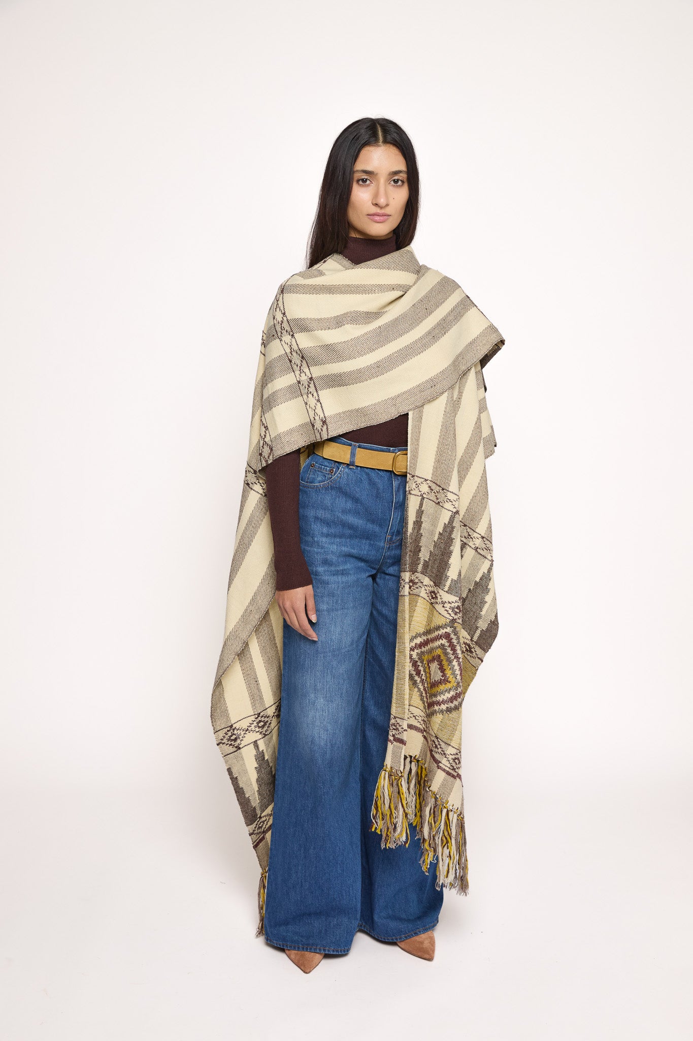 
                  
                    Handmade ZAZI wool cape inspired by Himalayan artisans, featuring intricate weaving, natural dyes, and tassels, modeled by a 174 cm tall woman.
                  
                
