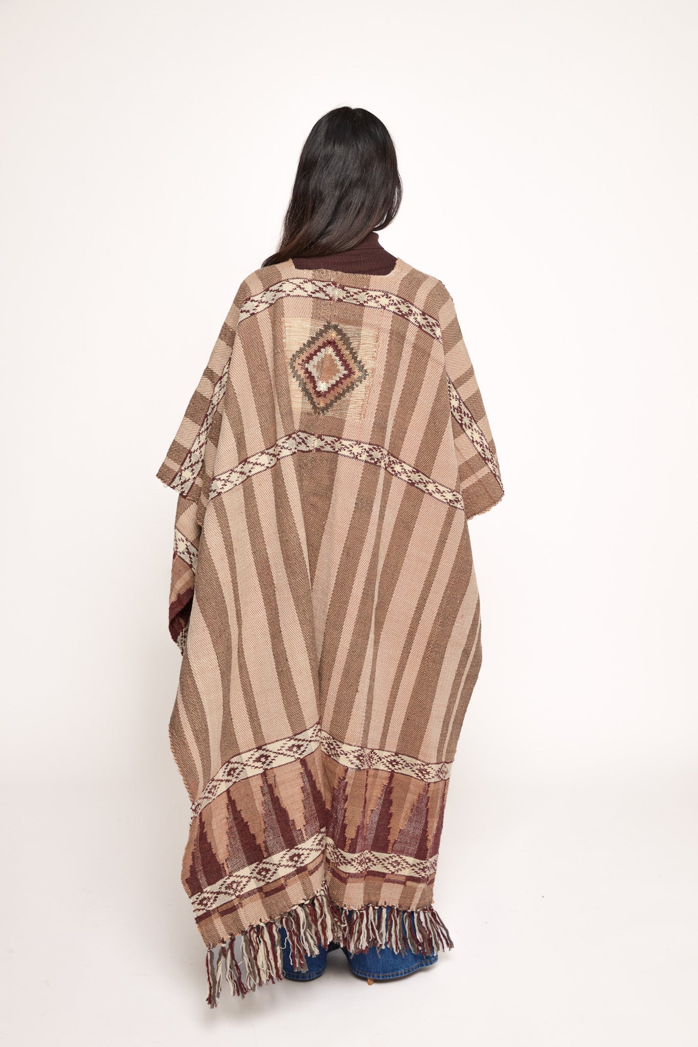 
                  
                    Handmade ZAZI wool cape inspired by Himalayan artisans, featuring intricate weaving, natural dyes, and tassels, modeled by a 174 cm tall woman.
                  
                