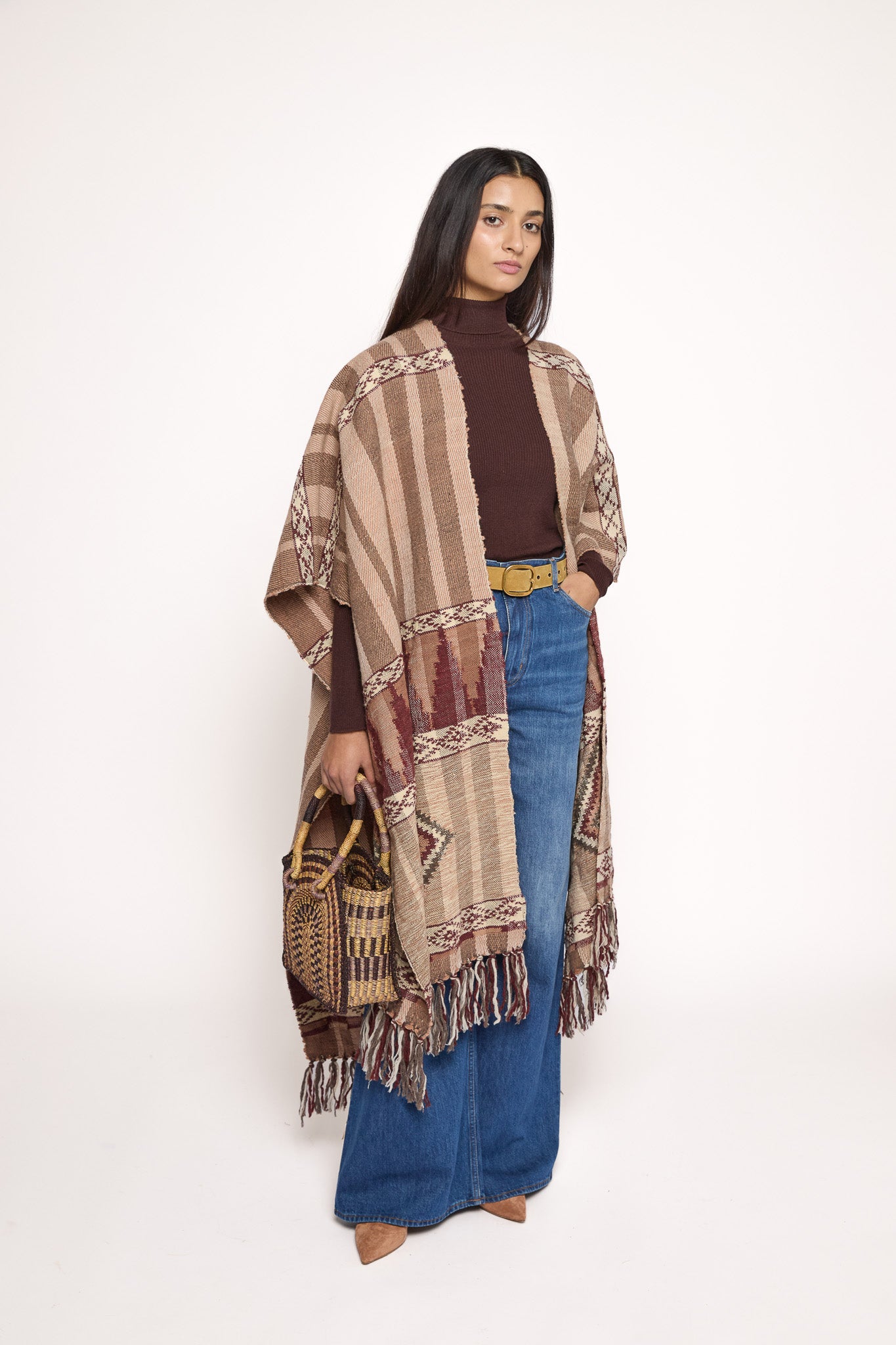 
                  
                    Handmade ZAZI wool cape inspired by Himalayan artisans, featuring intricate weaving, natural dyes, and tassels, modeled by a 174 cm tall woman.
                  
                