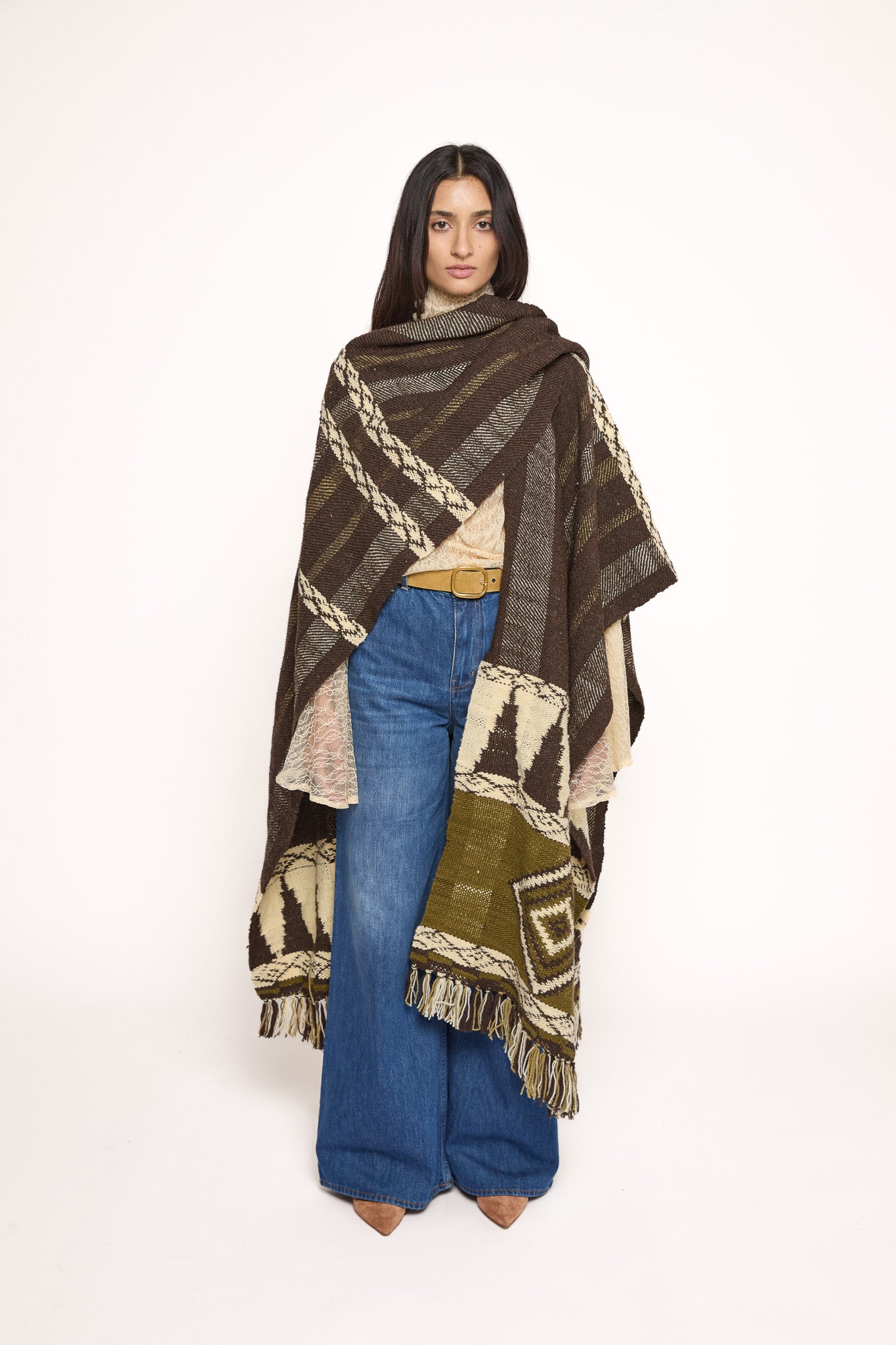 Handmade ZAZI wool cape inspired by Himalayan artisans, featuring intricate weaving, natural dyes, and tassels, modeled by a 174 cm tall woman.