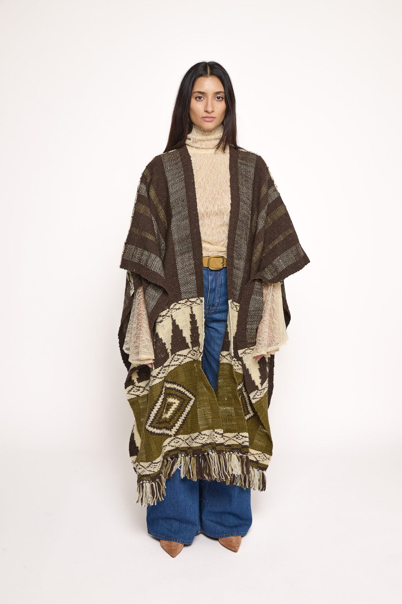 Handmade ZAZI wool cape inspired by Himalayan artisans, featuring intricate weaving, natural dyes, and tassels, modeled by a 174 cm tall woman.