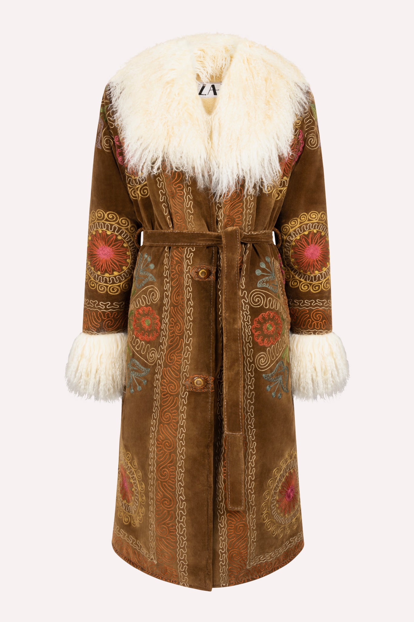 One-of-a-kind ZAZI Afghan coat crafted from vintage velours cotton suzani embroidery with an up-cycled sheepskin lining, featuring a belted 1970s Penny Lane silhouette and handcrafted by women artisans in Afghanistan.
