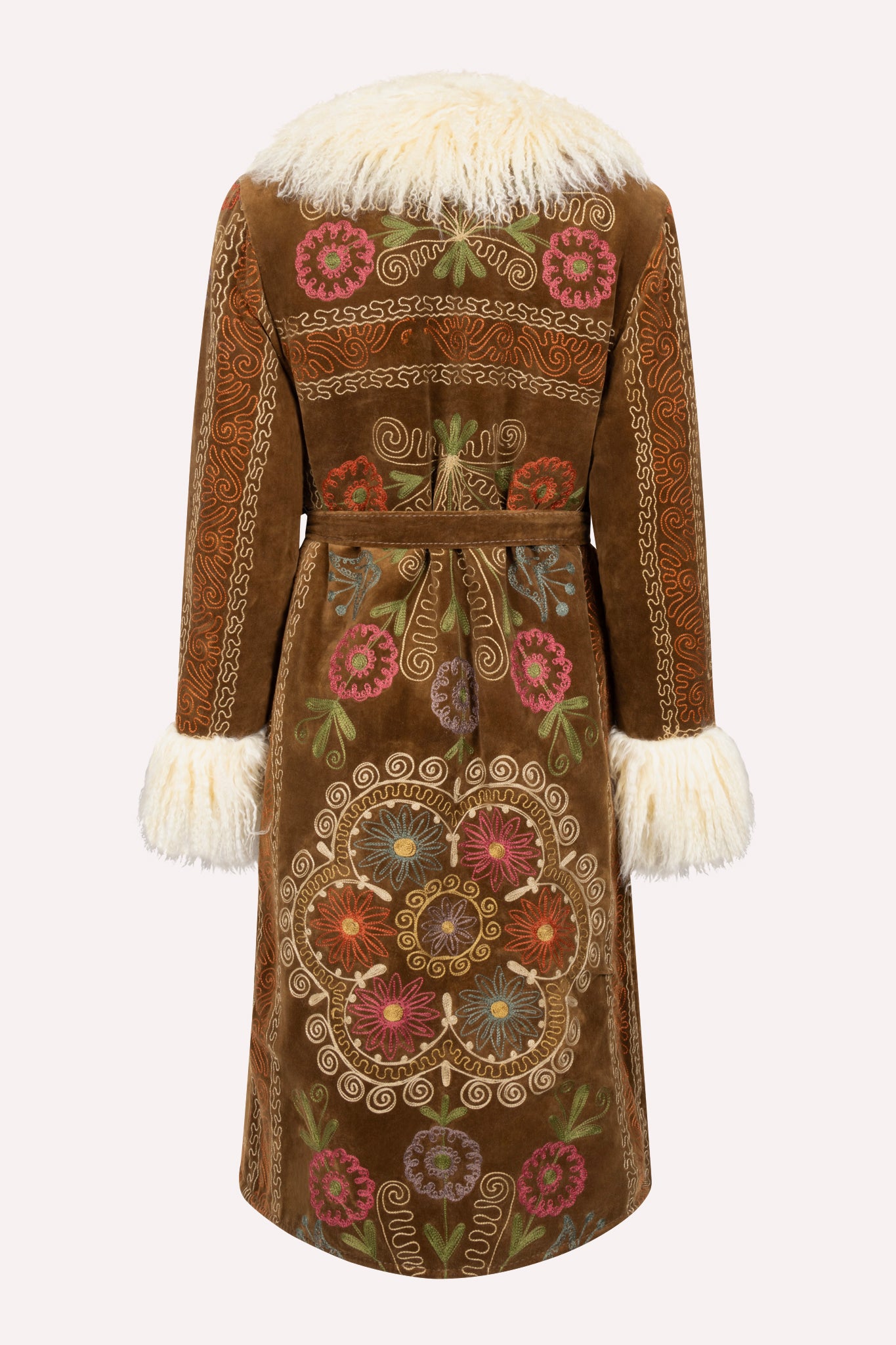 One-of-a-kind ZAZI Afghan coat crafted from vintage velours cotton suzani embroidery with an up-cycled sheepskin lining, featuring a belted 1970s Penny Lane silhouette and handcrafted by women artisans in Afghanistan.