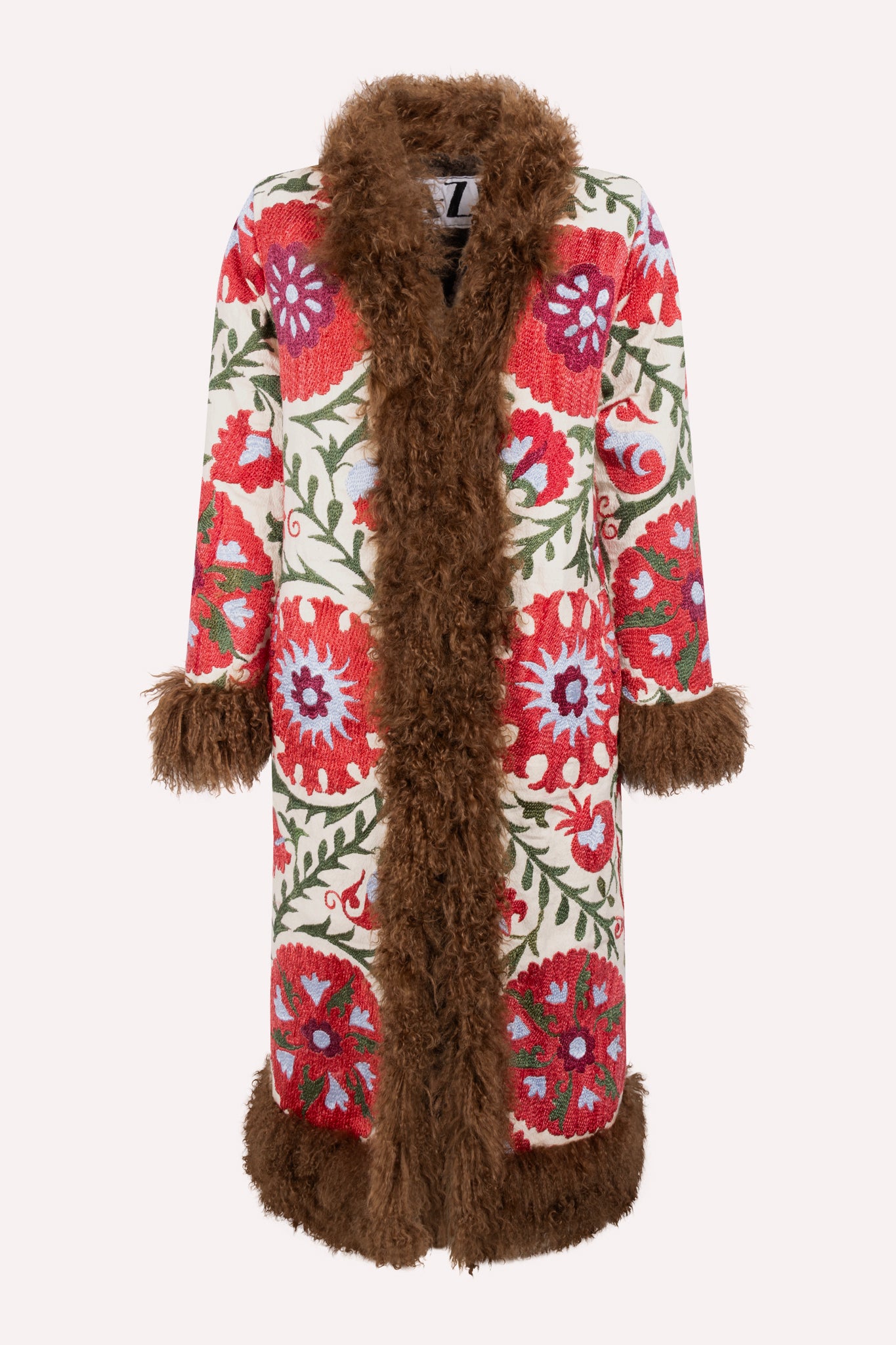 Handcrafted ZAZI Afghan coat made from vintage cotton suzani embroidery with upcycled sheepskin lining, featuring a straight 1970s-inspired silhouette with hook closures, created by women artisans in Afghanistan.