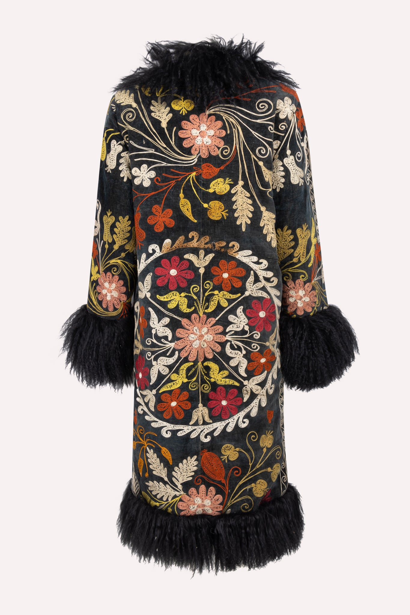 Handcrafted ZAZI Afghan coat made from vintage cotton suzani embroidery with upcycled sheepskin lining, featuring a straight 1970s-inspired silhouette with hook closures, created by women artisans in Afghanistan.