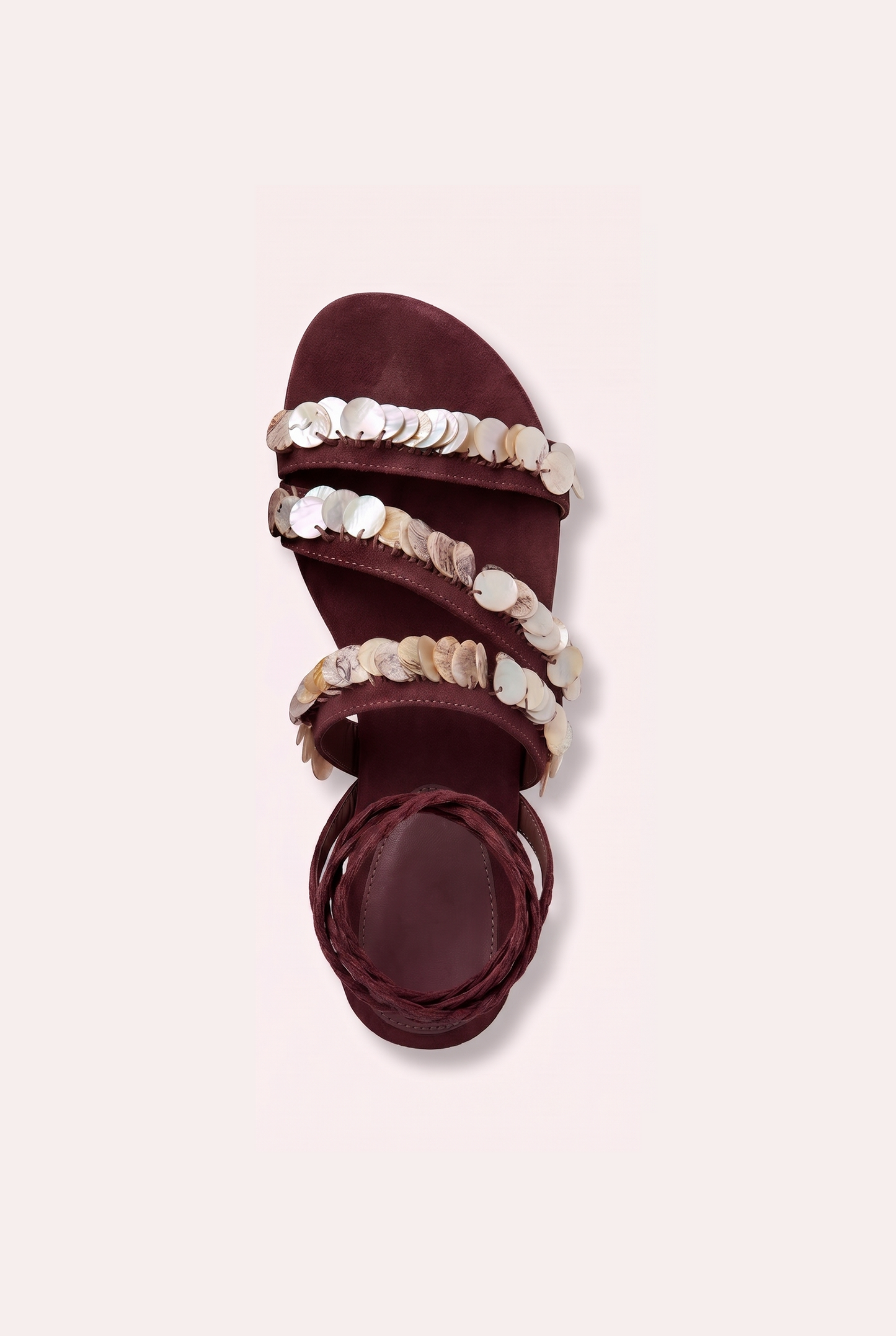Handcrafted tan suede flat sandals with mother of pearl beads and braided wrap-around ankle ties.