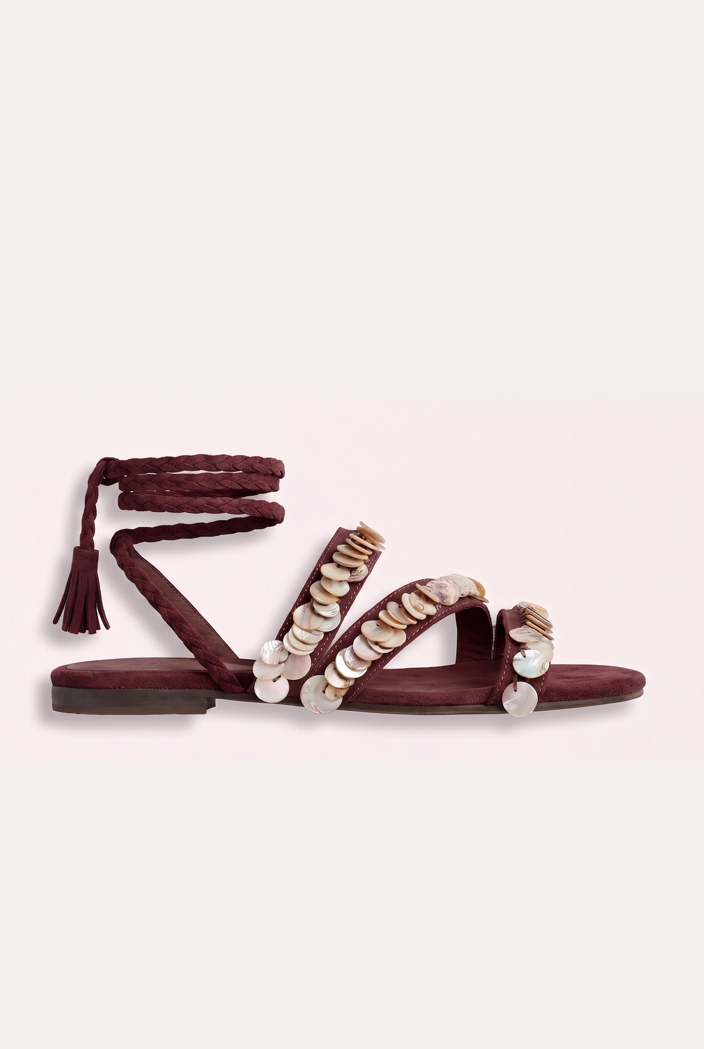 Handcrafted tan suede flat sandals with mother of pearl beads and braided wrap-around ankle ties.