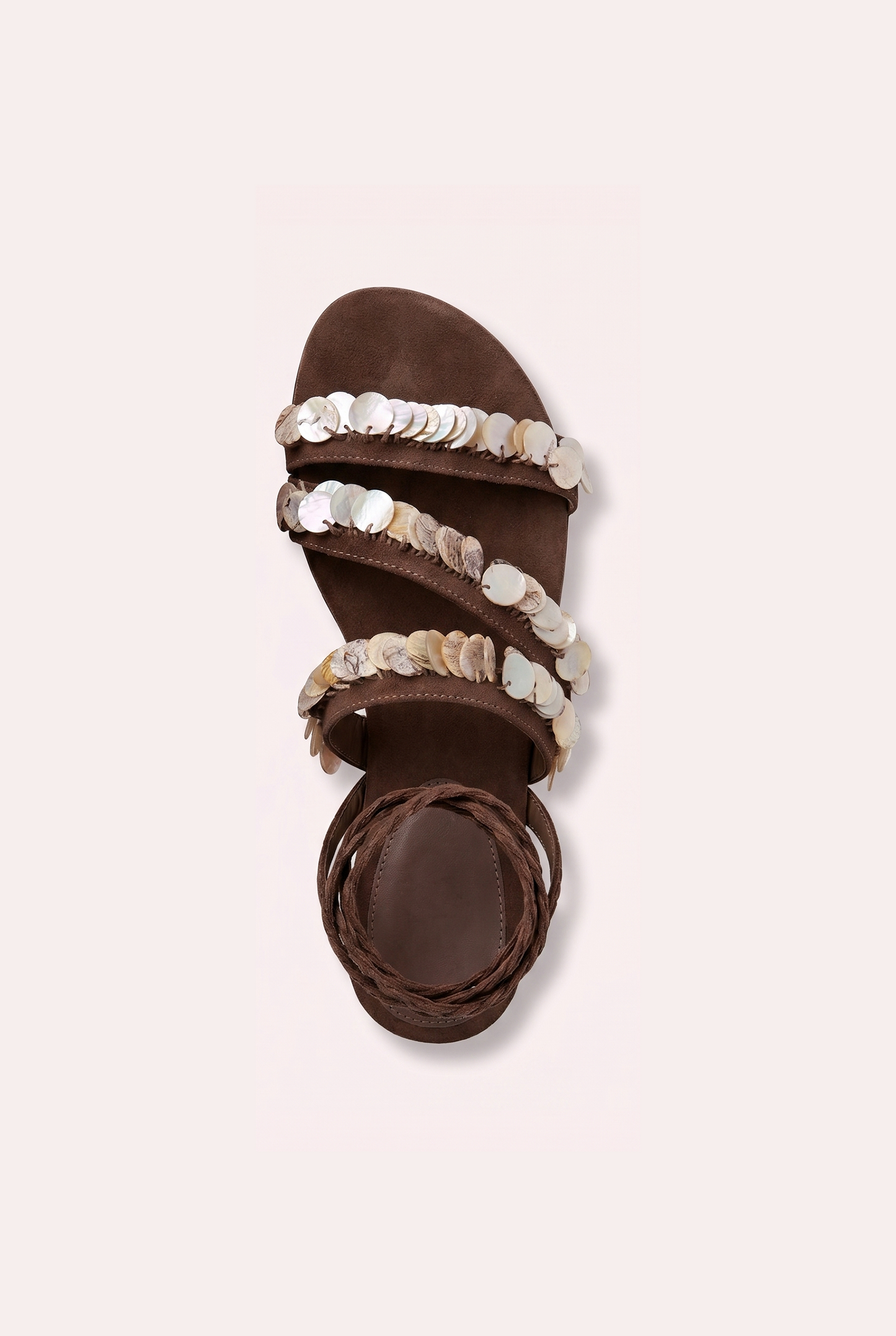 Handcrafted tan suede flat sandals with mother of pearl beads and braided wrap-around ankle ties.