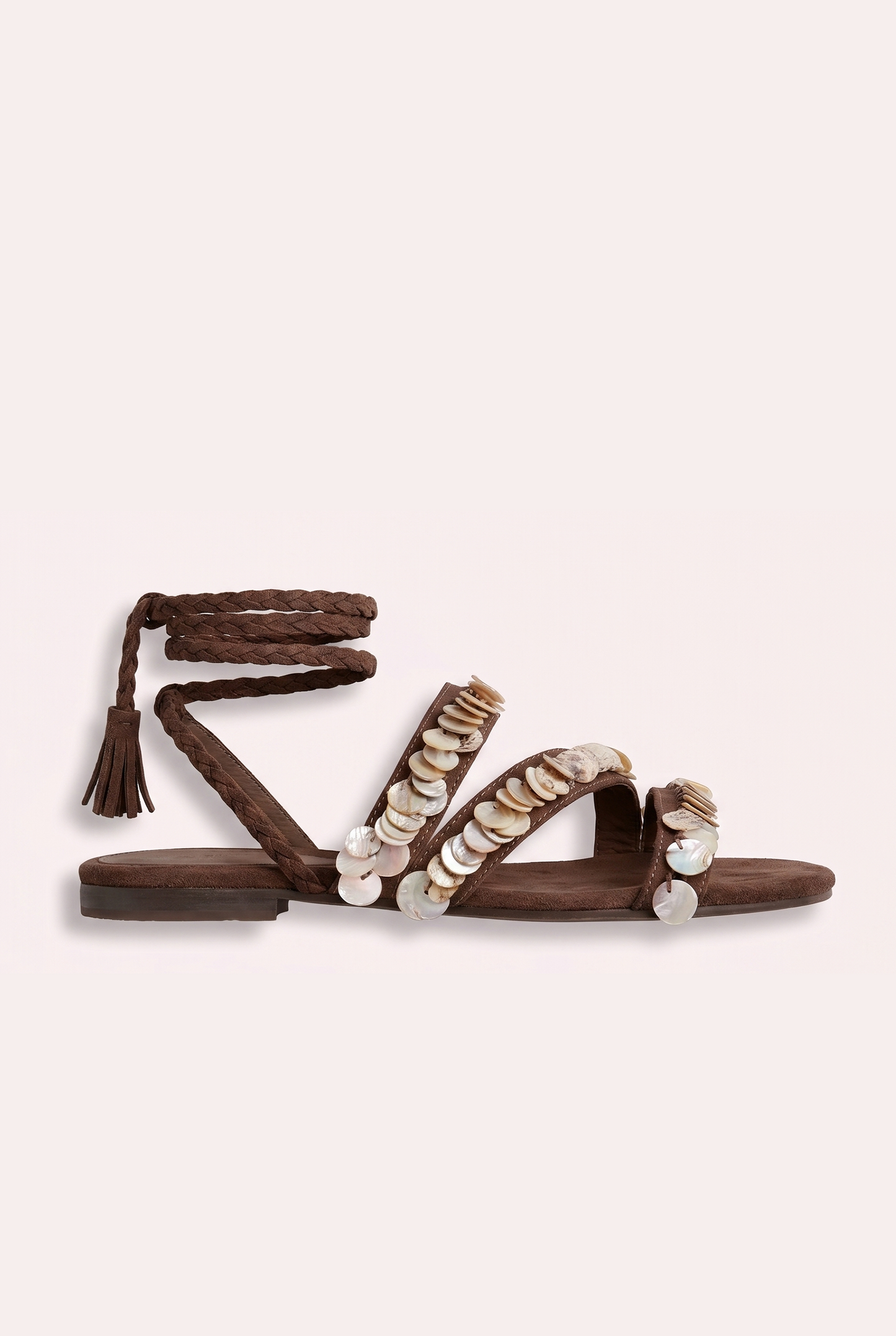 Handcrafted tan suede flat sandals with mother of pearl beads and braided wrap-around ankle ties.