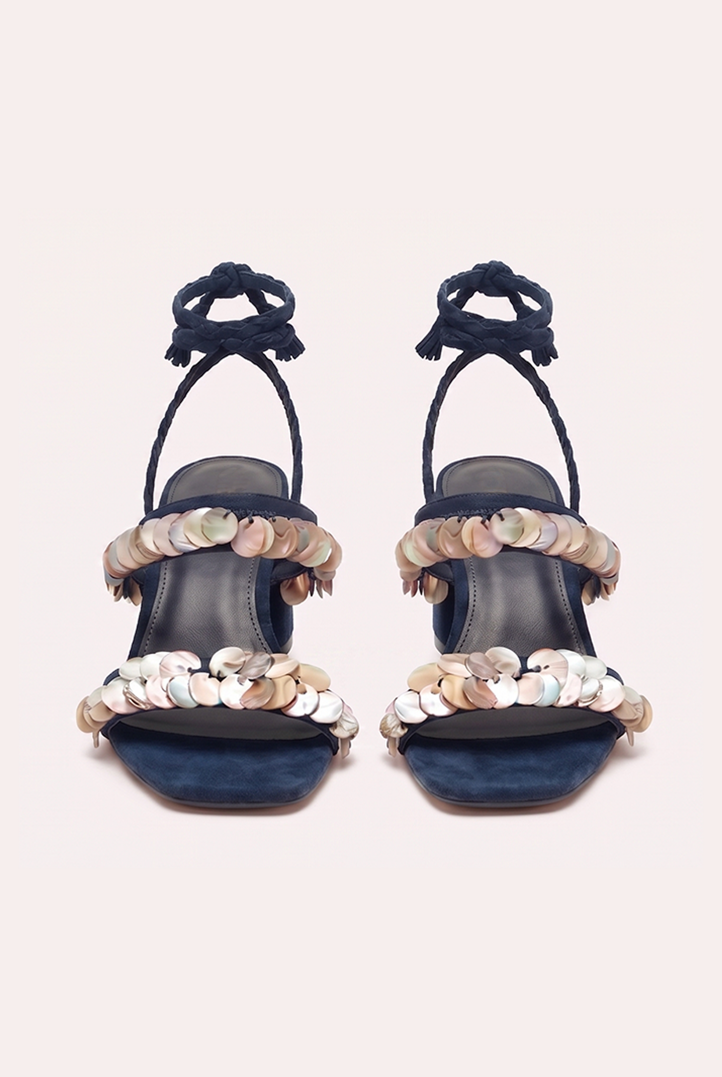 
                  
                    Handcrafted dark blue suede heel sandals with mother of pearl beads and braided wrap-around ankle ties.
                  
                