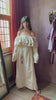Cream khadi cotton bohemian maxi dress with bird embroidery, off-shoulder ruffle neckline, flowing bell sleeves, and tie waist belt.